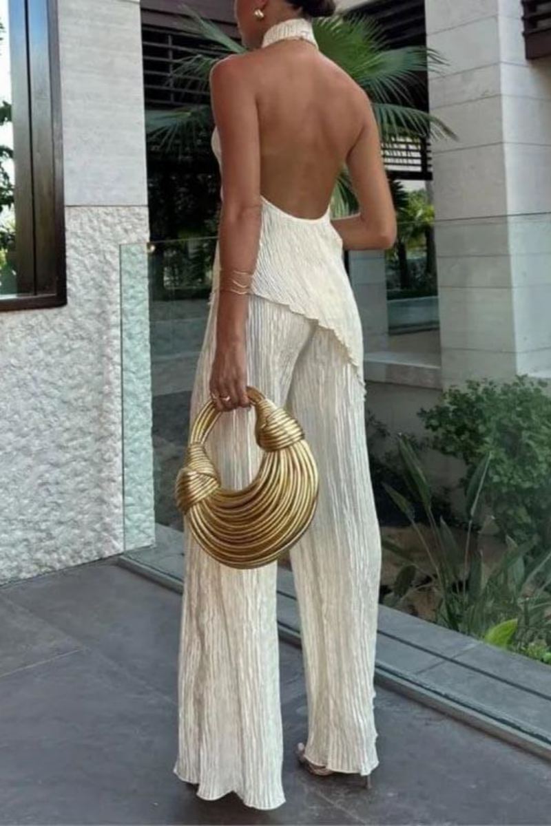 Woman in cream ribbed knit halter top and wide leg pants set.