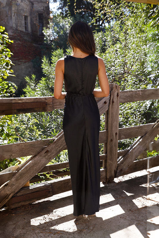 Woman in rust satin maxi dress with twisted bodice