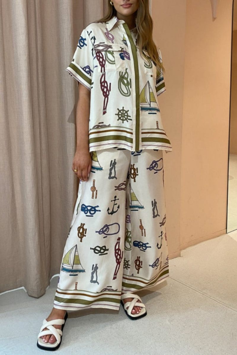 Woman wearing ivory satin pajama set with nautical print