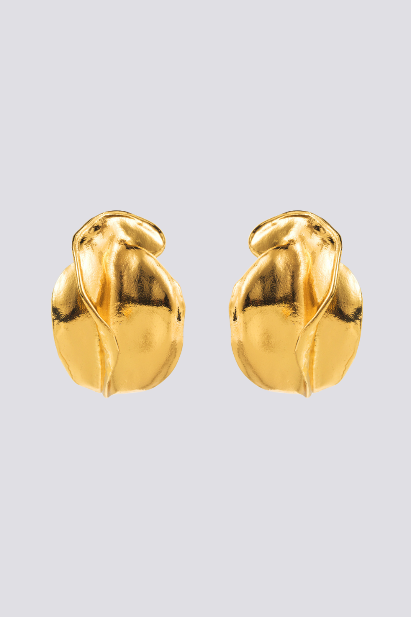 Close up of a gold abstract stud earring on an ear