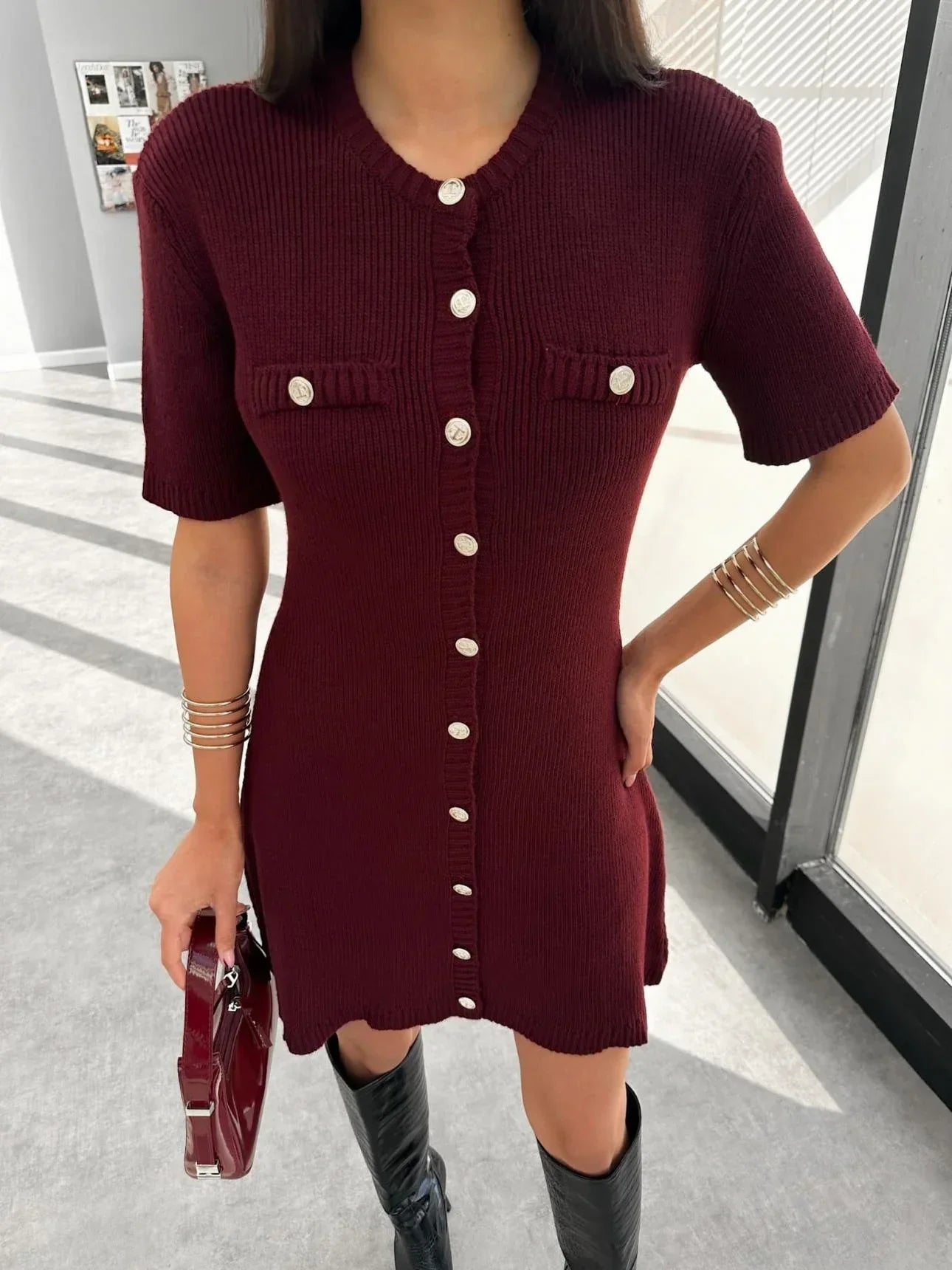 Woman in ivory boucle knit dress with brown handbag