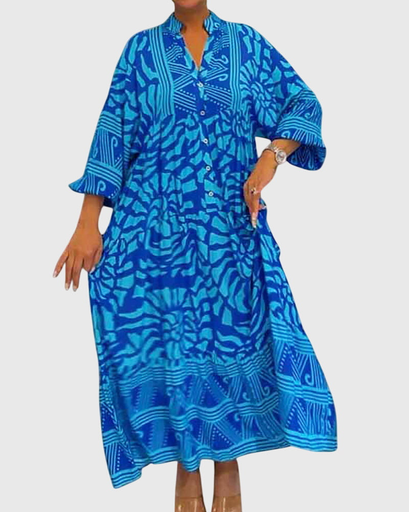 Purple - A woman wearing a vibrant pink and light pink abstract floral print maxi dress with long sleeves, a split V-neckline, and a tiered skirt featuring geometric border patterns.