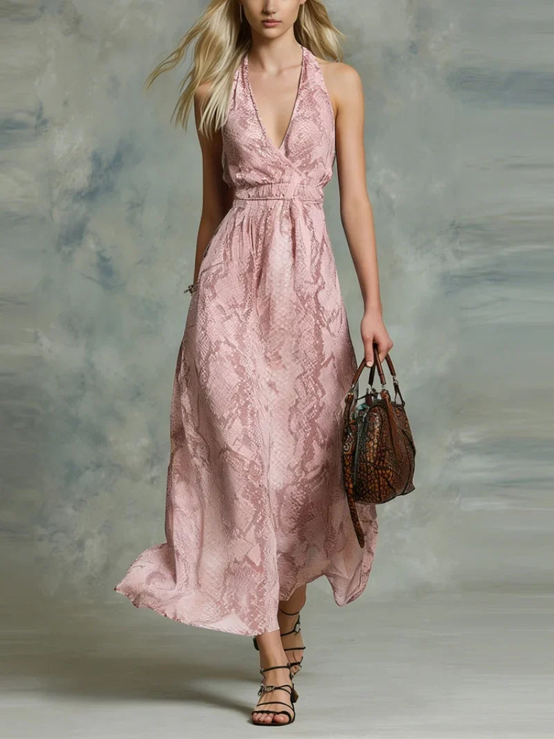 Pink - A woman wearing a flowing blue and white python print chiffon halter maxi dress with a plunging V-neckline, walking forward.