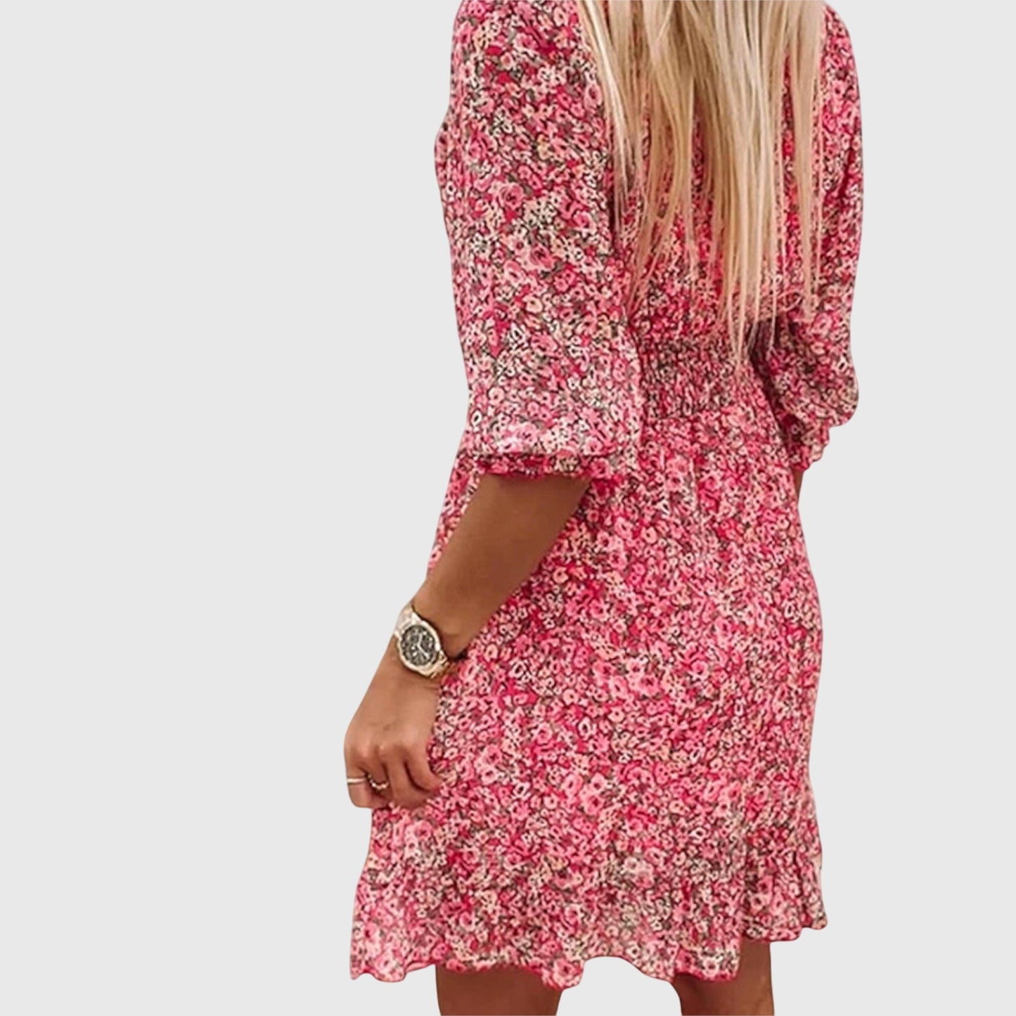 Pink - A woman wearing a blue and white ditsy floral print sundress with a v-neckline, three-quarter sleeves, a cinched waist, and a ruffled hem, holding a white quilted clutch bag.