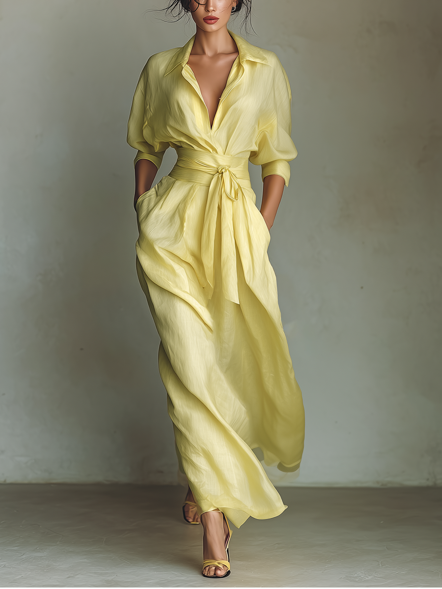 Yellow - Woman walking in a flowing, long-sleeve collared maxi shirtdress with a deep V-neckline and wide waist tie