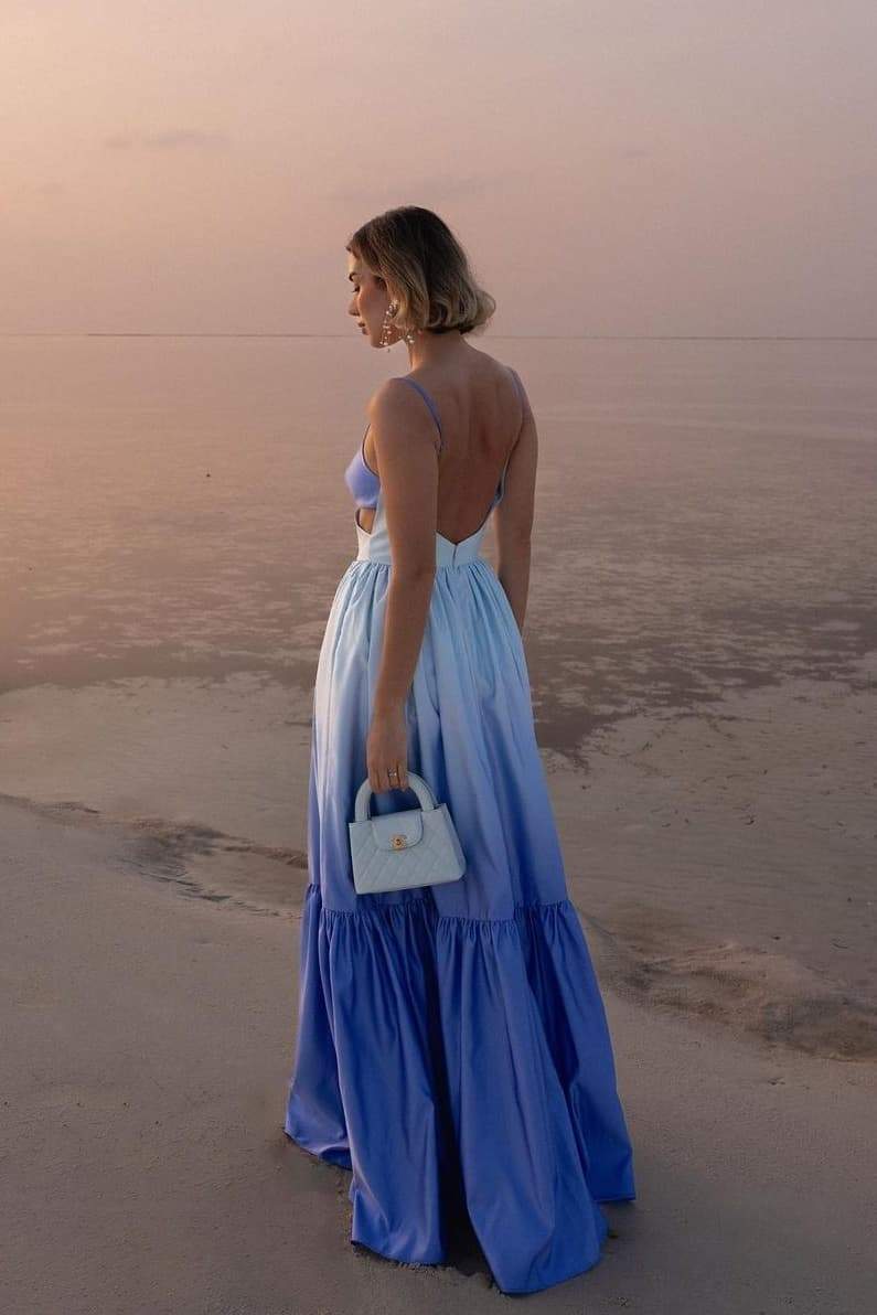 Woman wearing blue ombre satin maxi dress with cutout waist