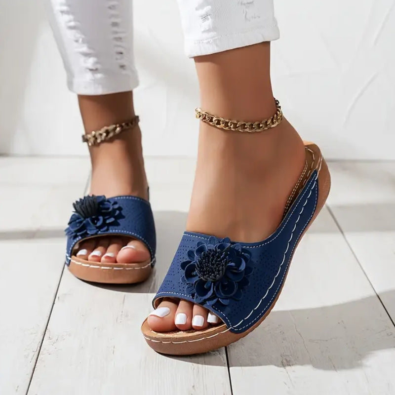 Black - Women's slip-on wedge sandals featuring a perforated upper with a 3D floral applique and contrast stitching.