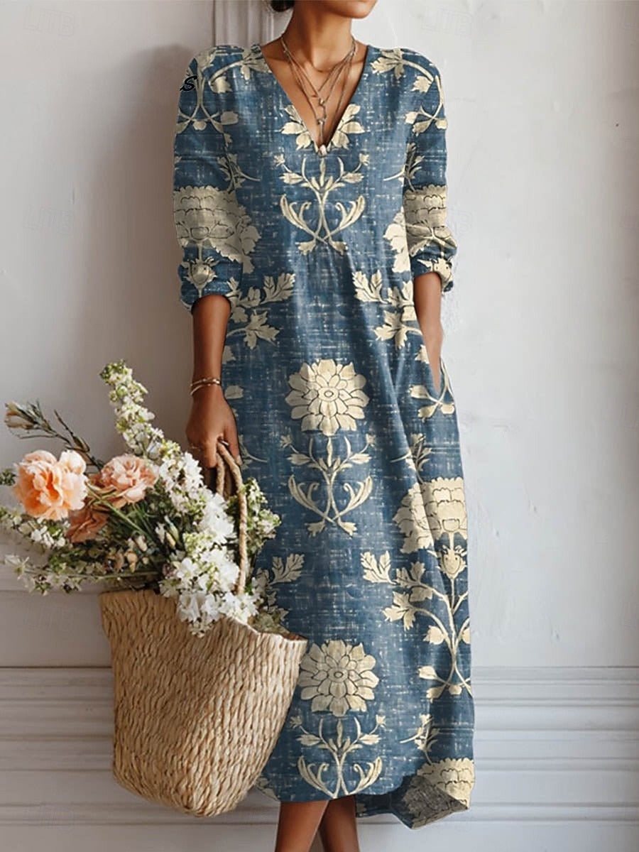 5XL - Woman wearing a long sleeve floral maxi dress with side pockets in a textured linen fabric