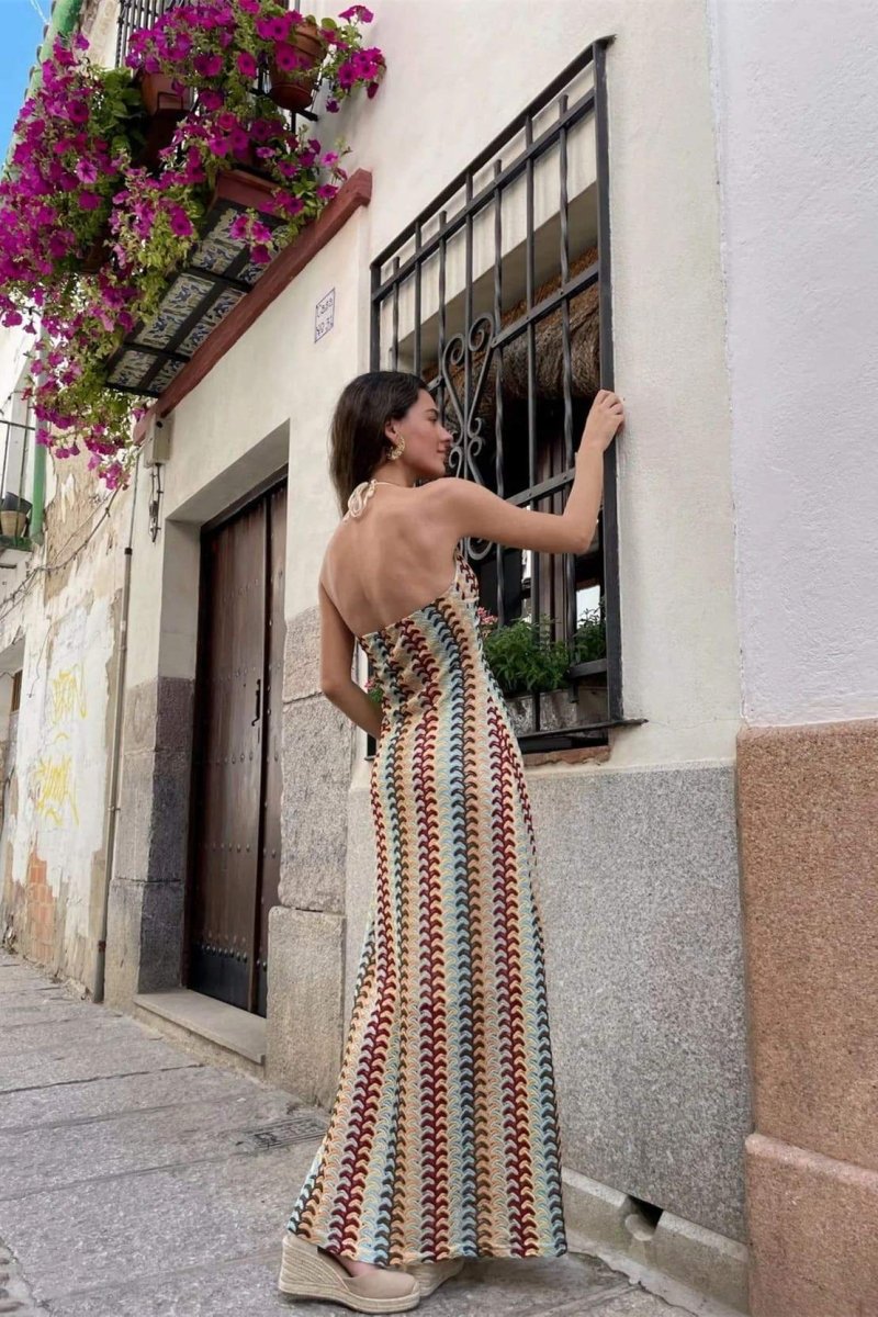 Woman in multi-color crochet knit halter maxi dress