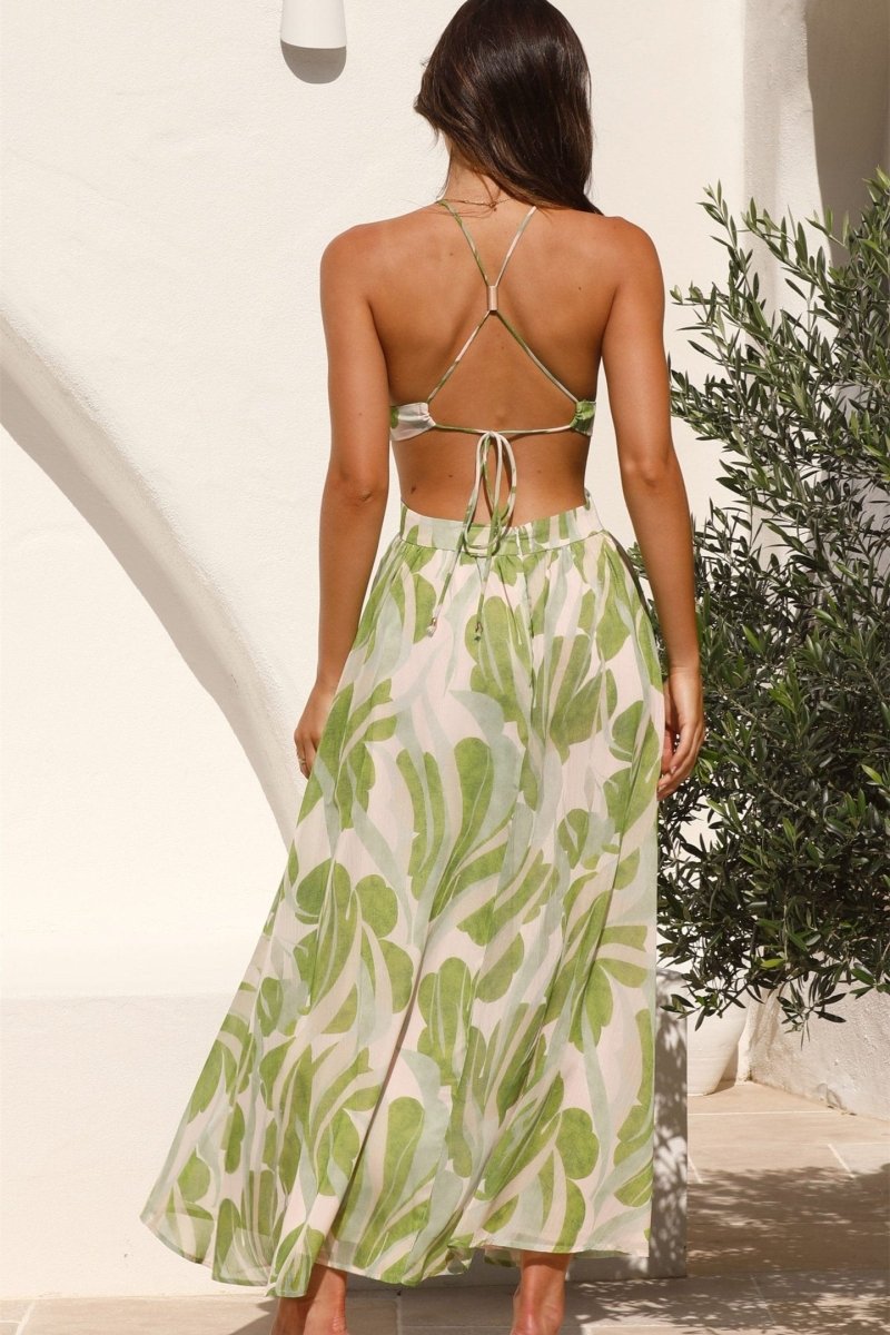 Woman in green and beige chiffon halter maxi dress with cutouts