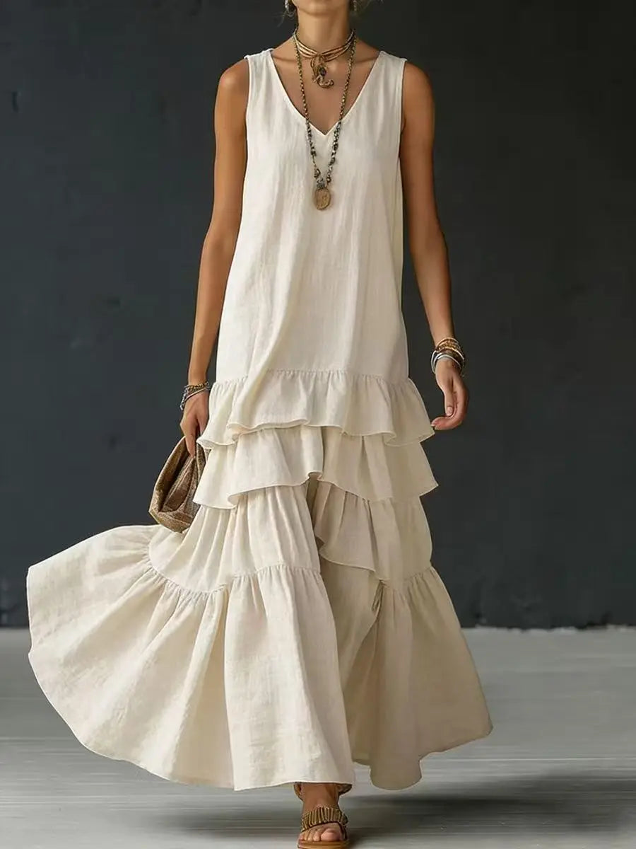 Beige - Woman wearing a sleeveless, v-neck, tiered ruffle maxi sundress in a textured fabric.