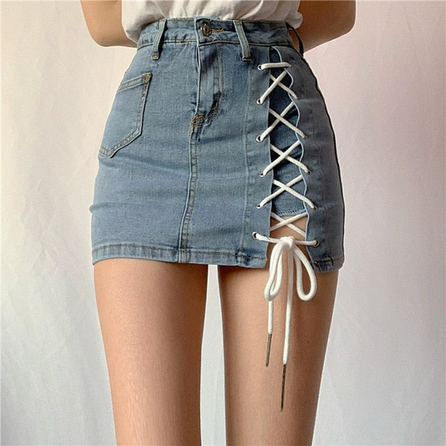 Woman wearing a light blue denim mini skirt with white lace-up side detail.