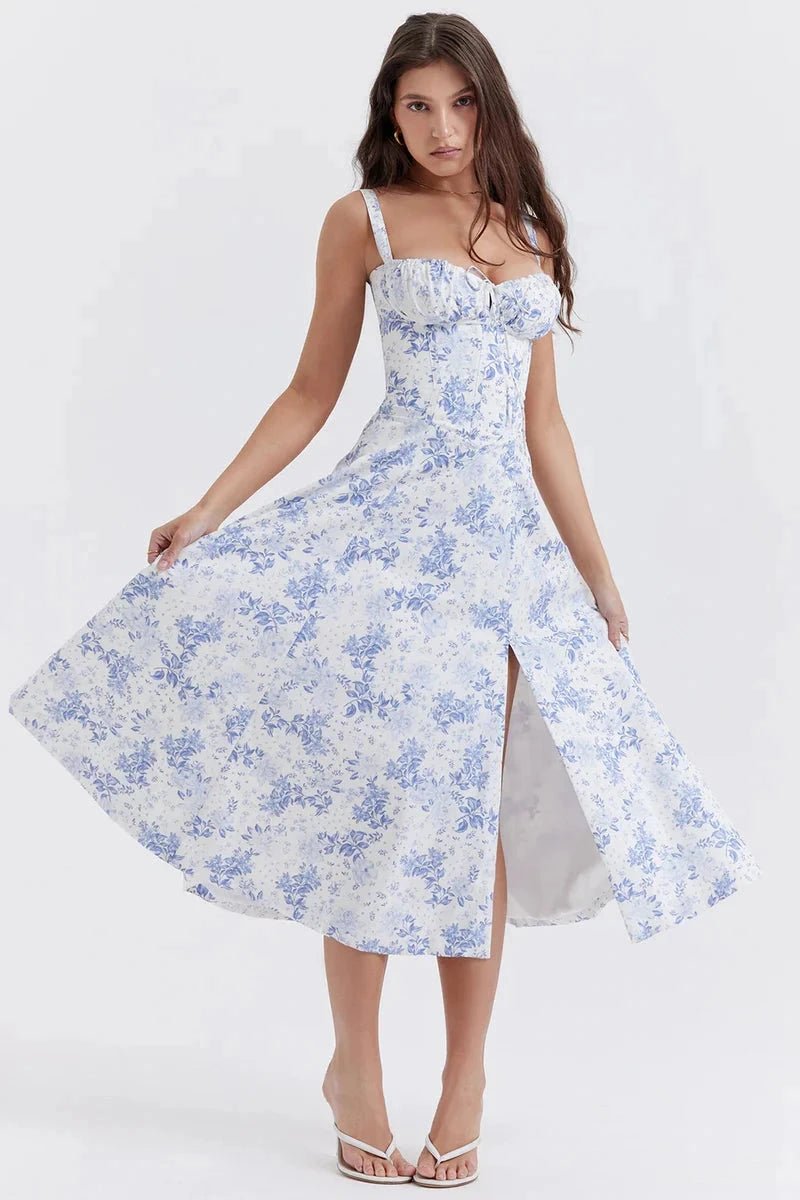 Blue Floral Linsay - Woman wearing a floral sweetheart midi dress with wide straps, a fitted bodice, and a flowing A-line skirt with a front slit.