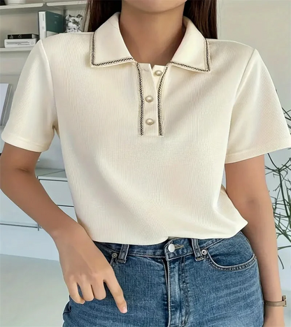 Woman wearing off-white ribbed knit polo shirt with pearl buttons.