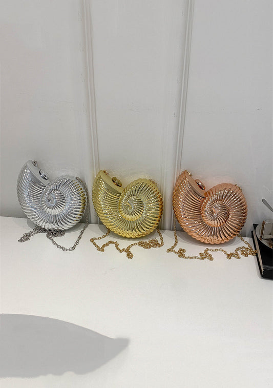 Three metallic seashell clutches in silver, gold, and rose gold with chain straps