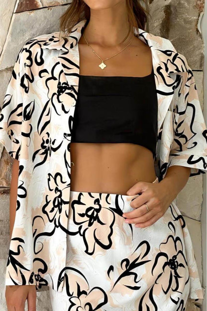 Woman in white linen floral skirt set with black crop top