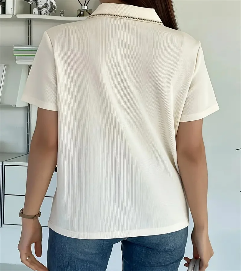 Woman wearing off-white ribbed knit polo shirt with pearl buttons.