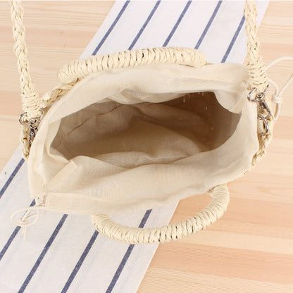 Woven straw handbag with round handle and braided strap