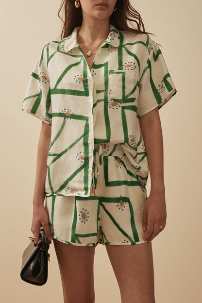 Woman wearing white and green linen short set with brown leather handbag