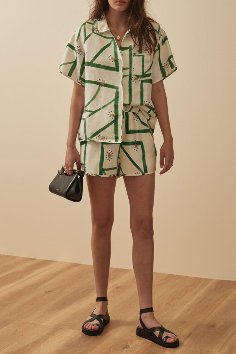 Woman wearing white and green linen short set with brown leather handbag