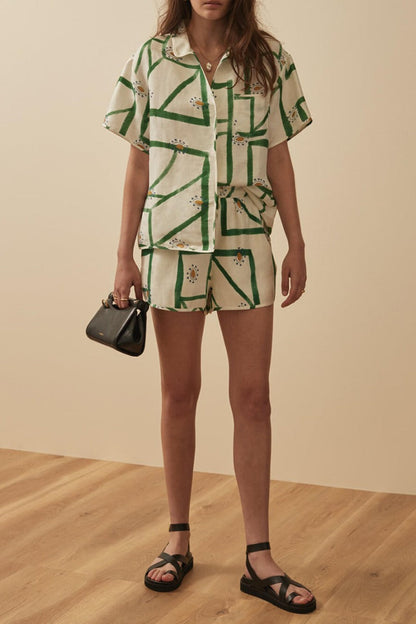 Woman wearing white and green linen short set with brown leather handbag
