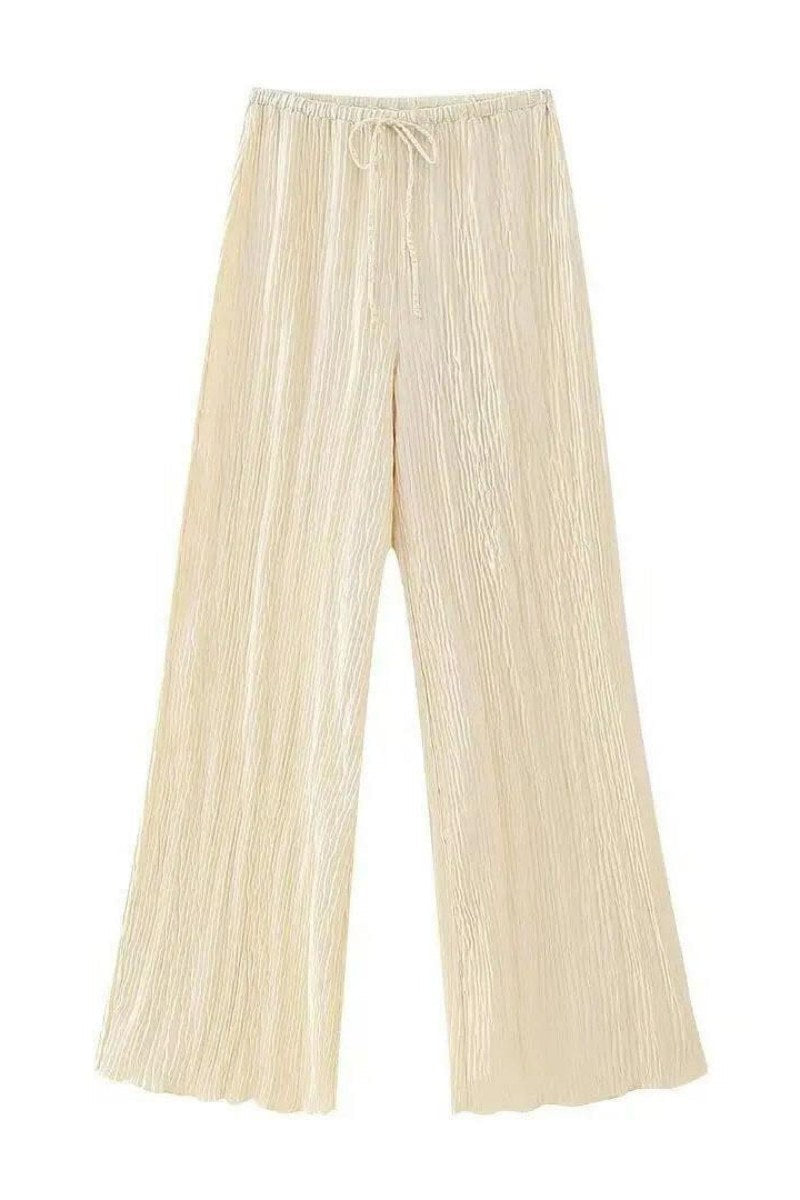 Woman in cream ribbed knit halter top and wide leg pants set.