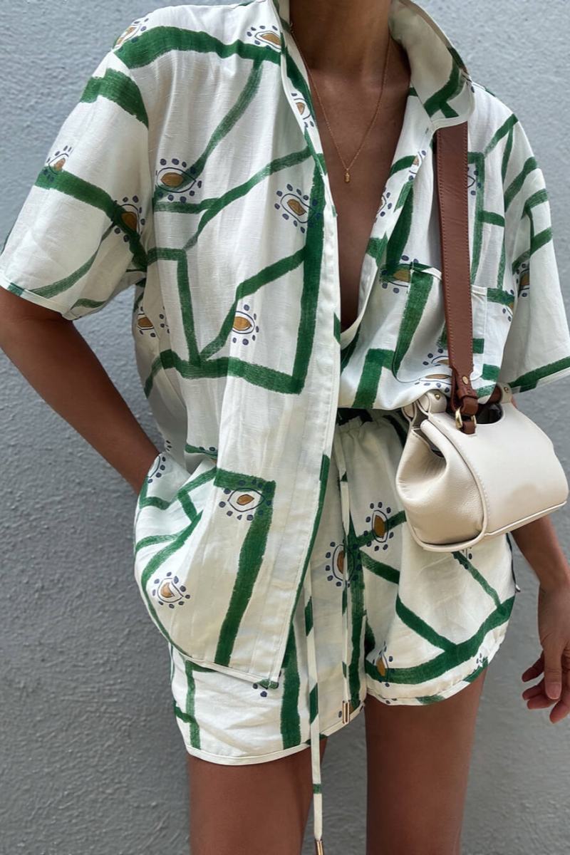 Woman wearing white and green linen short set with brown leather handbag