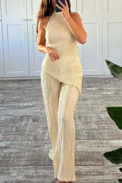 Woman in cream ribbed knit halter top and wide leg pants set.