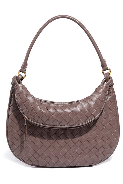 Woman holding dark brown woven leather hobo bag