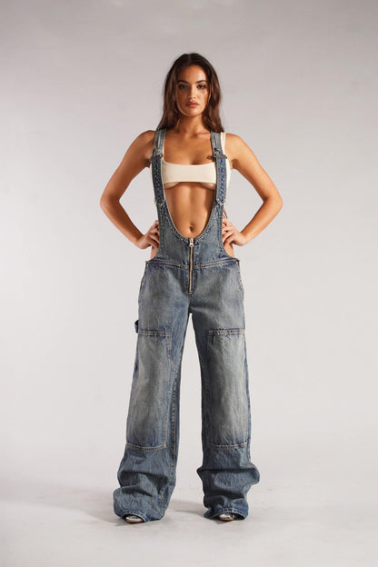 Woman wearing olive green cotton canvas overalls with cutout sides and white crop top