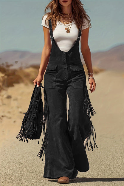 Woman in brown suede fringe overalls and hat walking in desert landscape