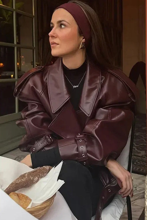 Woman in burgundy faux leather oversized jacket with matching headband and purse