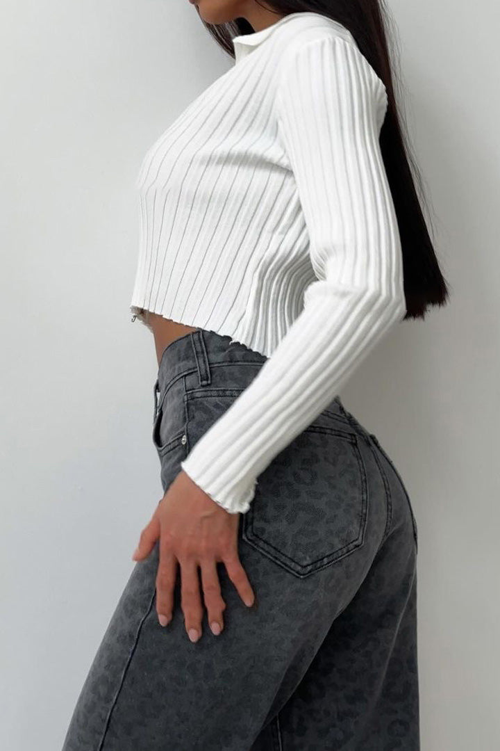 Woman in gray leopard print wide leg jeans and white ribbed knit top