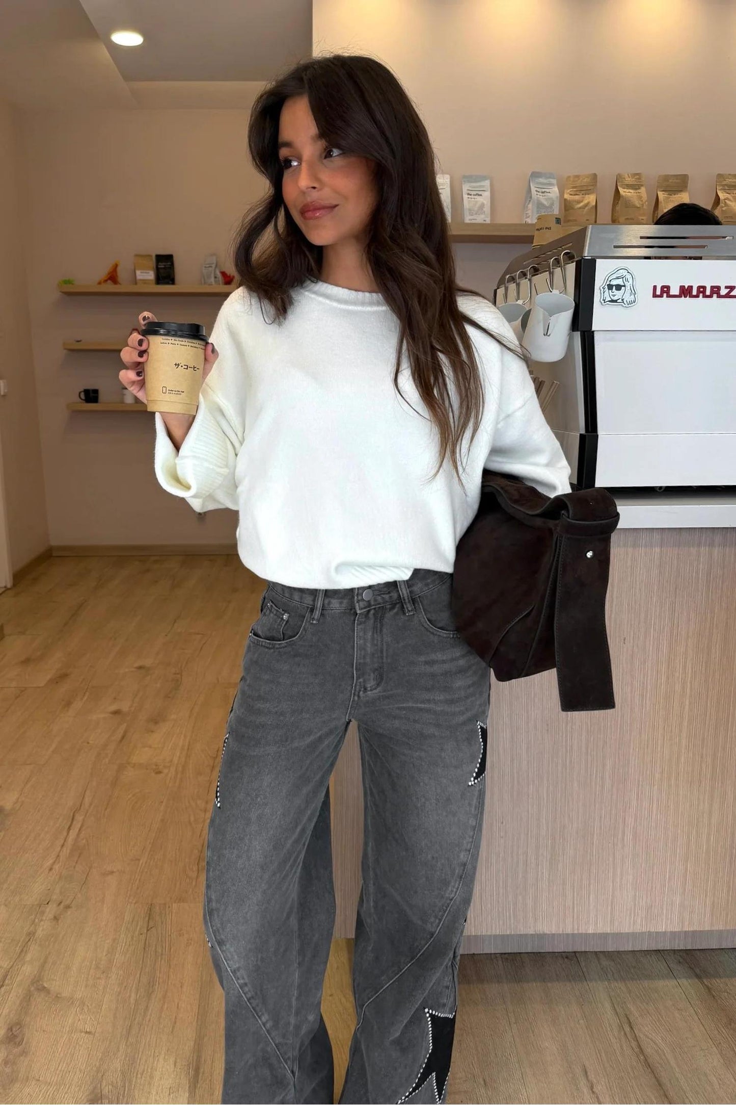 Woman wearing light wash wide leg jeans with star appliqués
