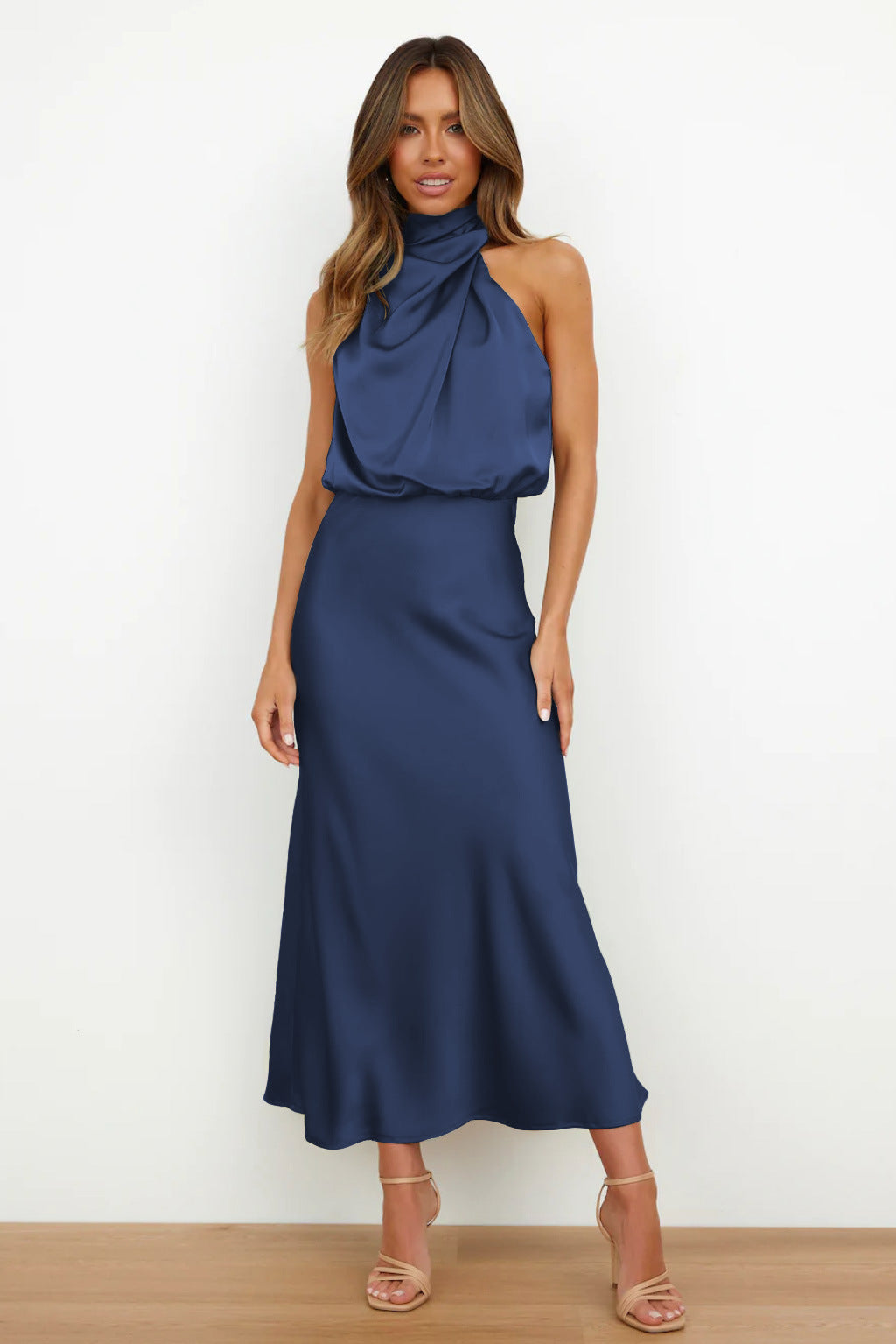 Woman in navy blue satin halter midi dress