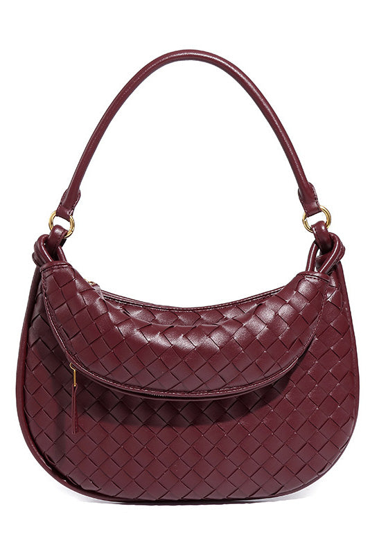 Woman holding dark brown woven leather hobo bag
