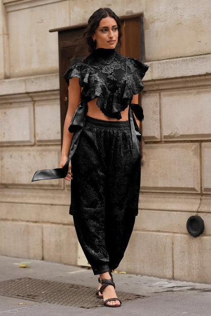 Woman in cream lace crop top and jeans on city street