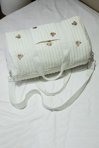 Off-white quilted duffle bag with teddy bear embroidery hanging on a coat rack