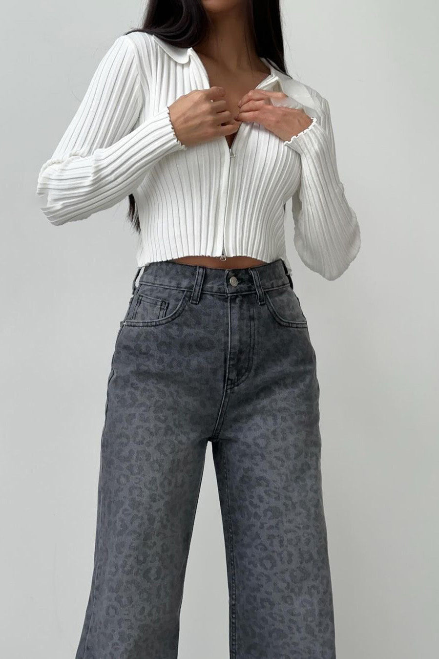 Woman in gray leopard print wide leg jeans and white ribbed knit top
