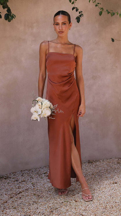 Woman in copper satin slip dress holding white flowers