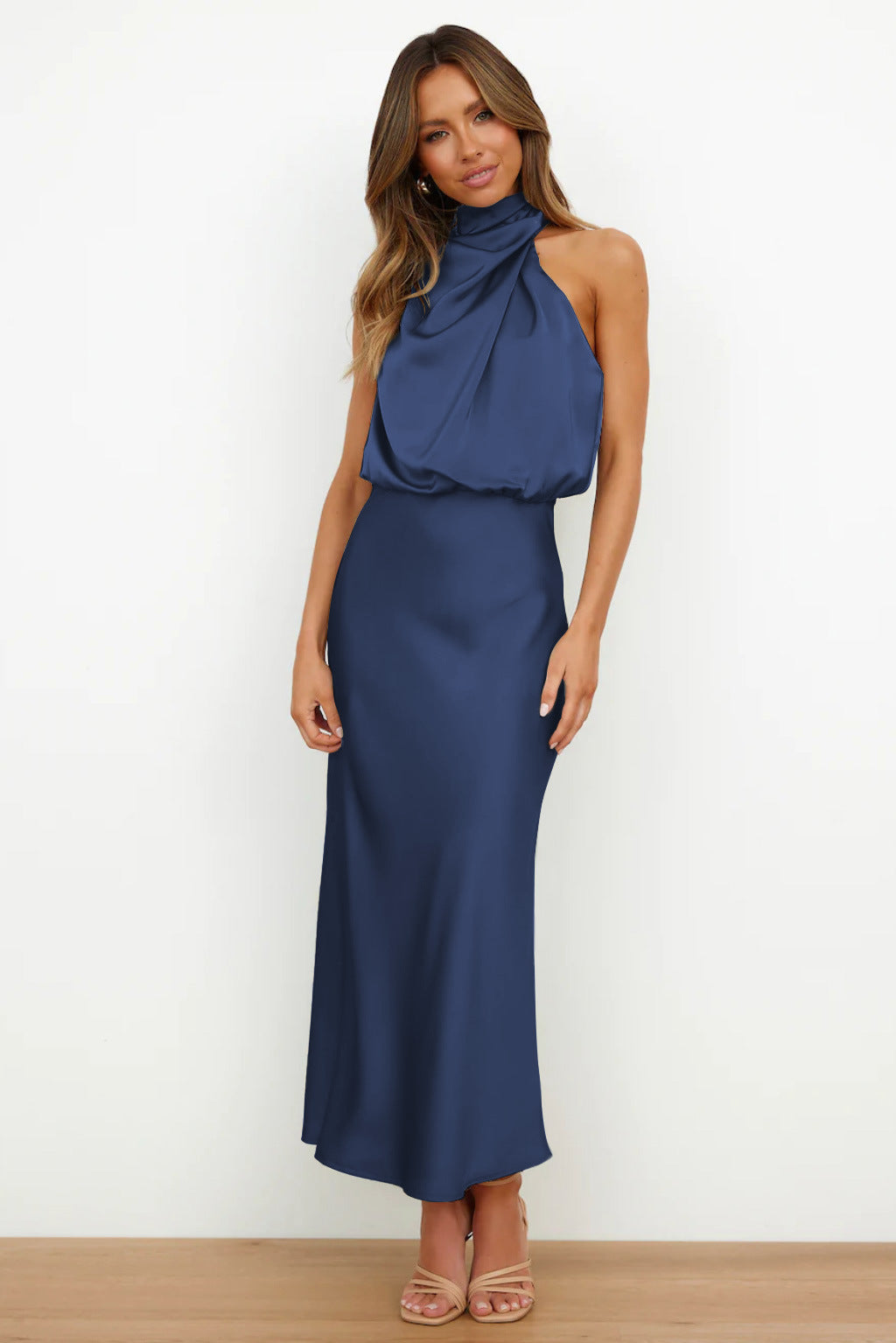Woman in navy blue satin halter midi dress