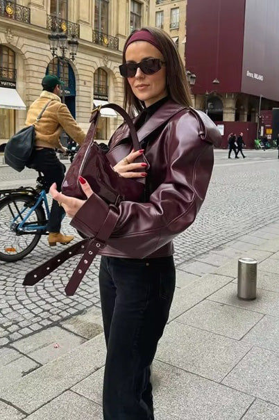 Woman in burgundy faux leather oversized jacket with matching headband and purse