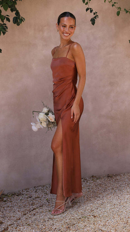 Woman in copper satin slip dress holding white flowers