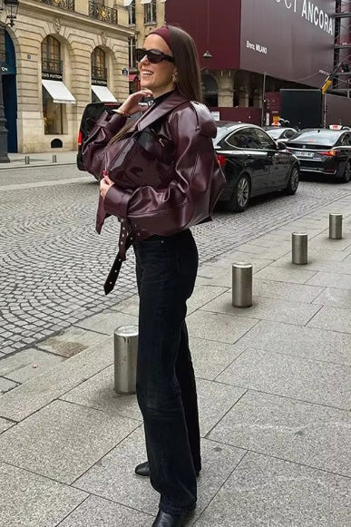 Woman in burgundy faux leather oversized jacket with matching headband and purse