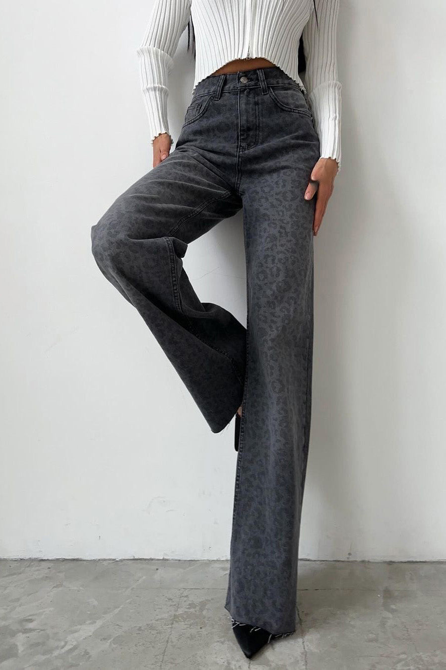 Woman in gray leopard print wide leg jeans and white ribbed knit top