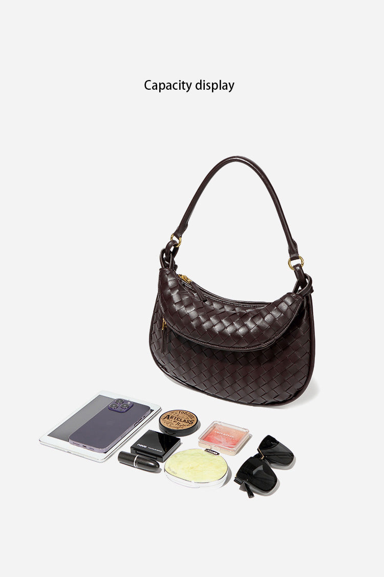 Woman holding dark brown woven leather hobo bag