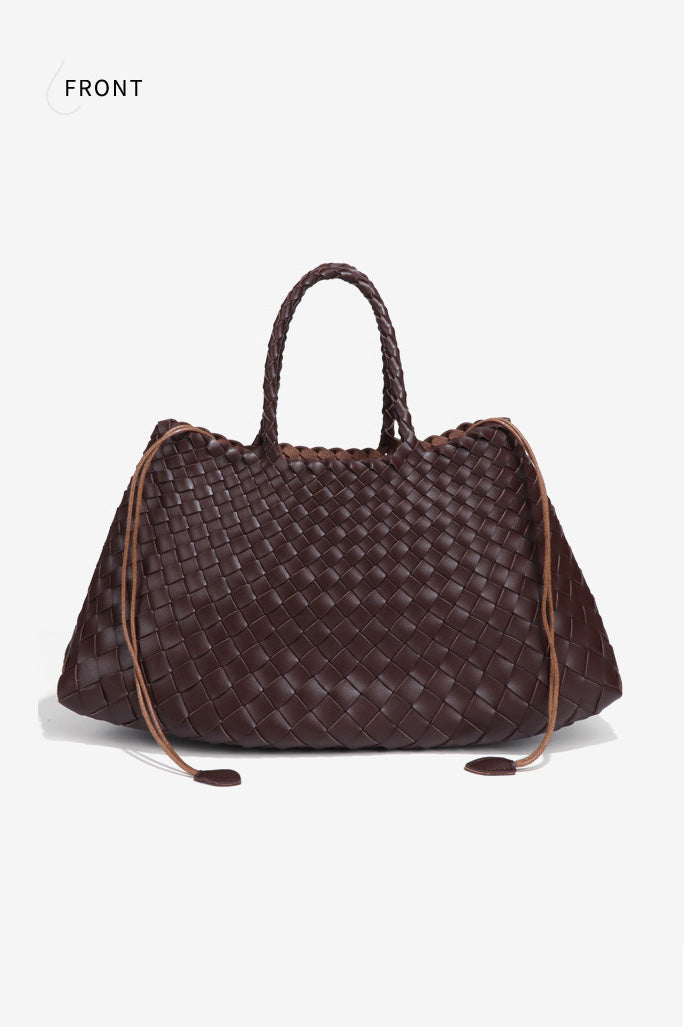 Woman holding brown woven tote bag