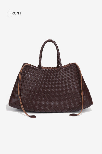 Woman holding brown woven tote bag