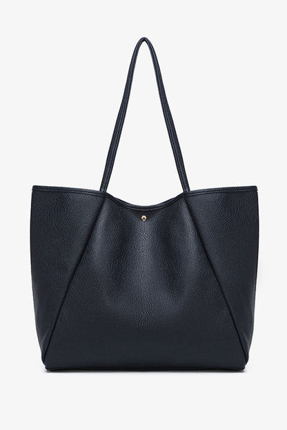 Front view of black textured tote bag with top handles and gold button detail