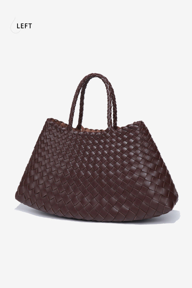 Woman holding brown woven tote bag